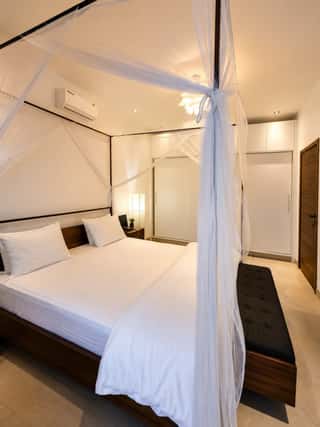 The canopy bed, with fitted wardrobes behind it
