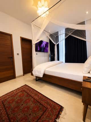 The principal suite, with a rug and a wall-mounted screen