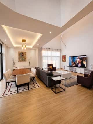 The dining table and living area under the double-height ceiling