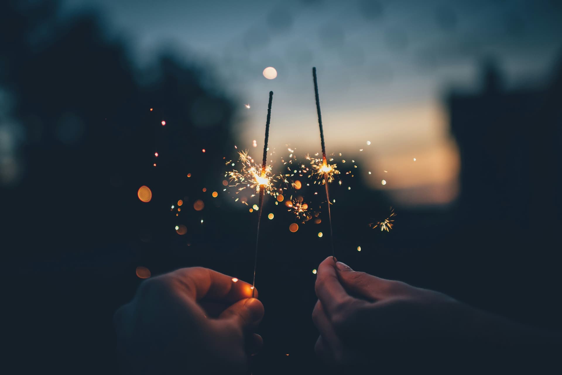 Two sparklers lit at dusk