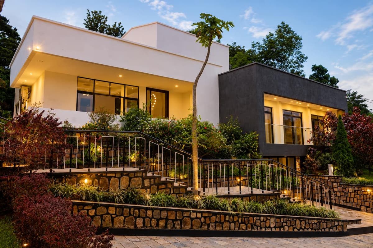 The villa above its lit stone terraces and garden stair at dusk. Urugwiro, Kacyiru.
