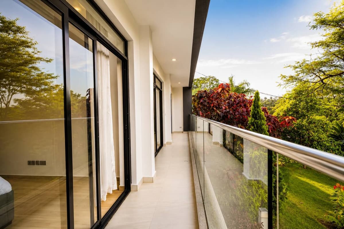 The long terrace, with a glass balustrade, looking over the garden and the trees. Urugwiro, Kacyiru.
