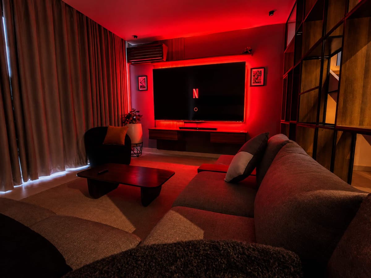 The Red Room cinema, lit in red, with a wall TV and deep sofas. Amahoro, Kibagabaga.