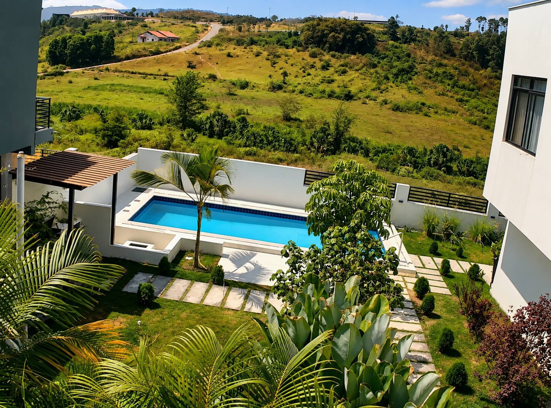 The pool beside the villa, with green hills beyond. Amahoro, Kibagabaga.