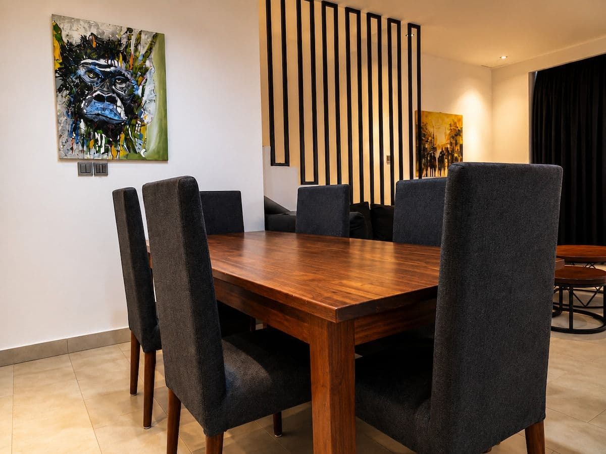 The dining table, with chairs for six and a colourful painting. Ikaze, Kicukiro.