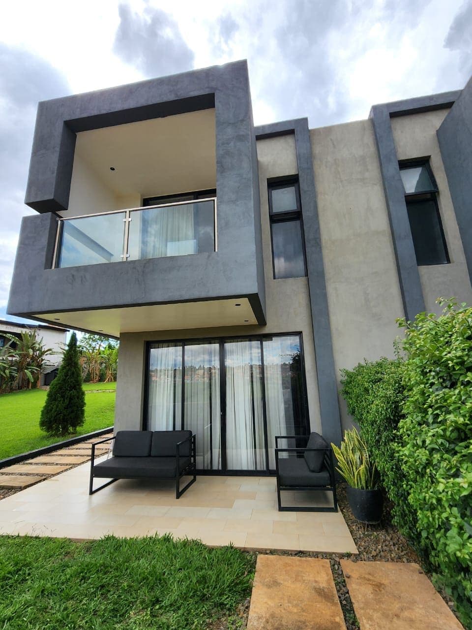 The house from the garden: an upper balcony above a shaded patio