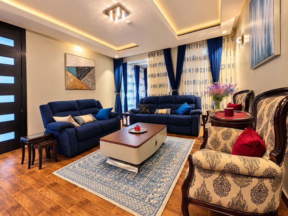 The lounge, with armchairs, blue sofas and a coffee table. Irebero, Rebero.