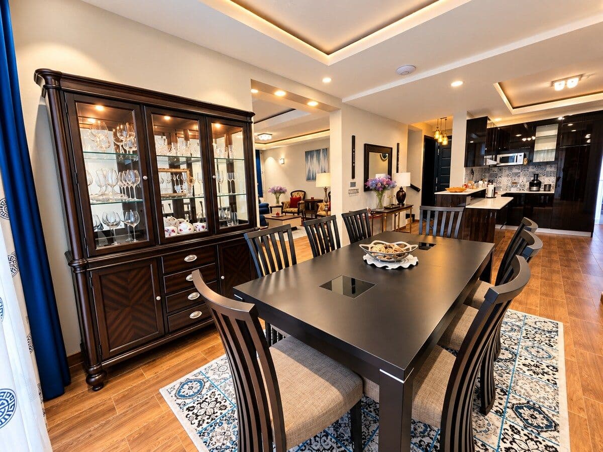 A dark wood dining table beside a glass-fronted china cabinet. Irebero, Rebero.