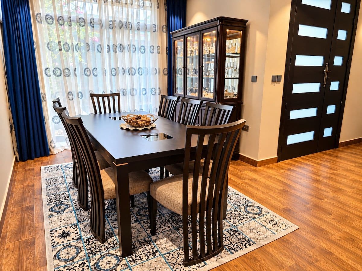 The dining table by the tall windows, with a display cabinet. Irebero, Rebero.