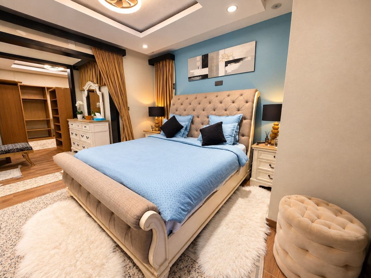 The principal bedroom, with a tufted sleigh bed and a sheepskin rug. Irebero, Rebero.