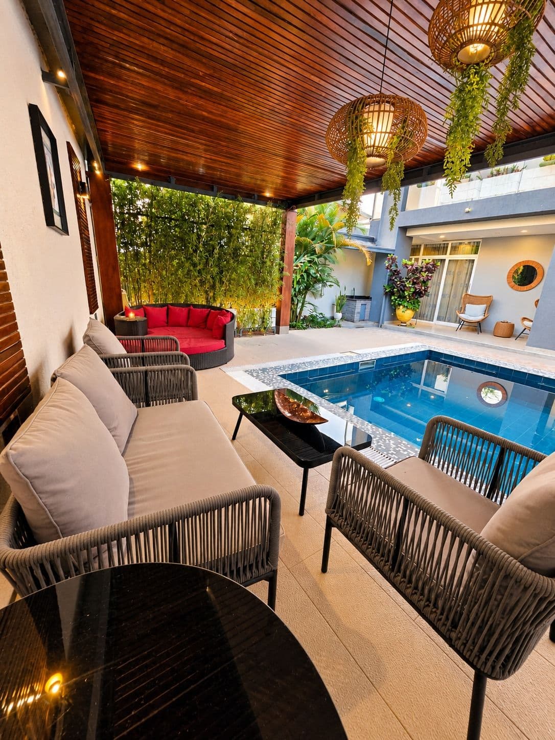 A covered lounge beside the pool at Irebero, with lamps lit, Rebero, Kigali