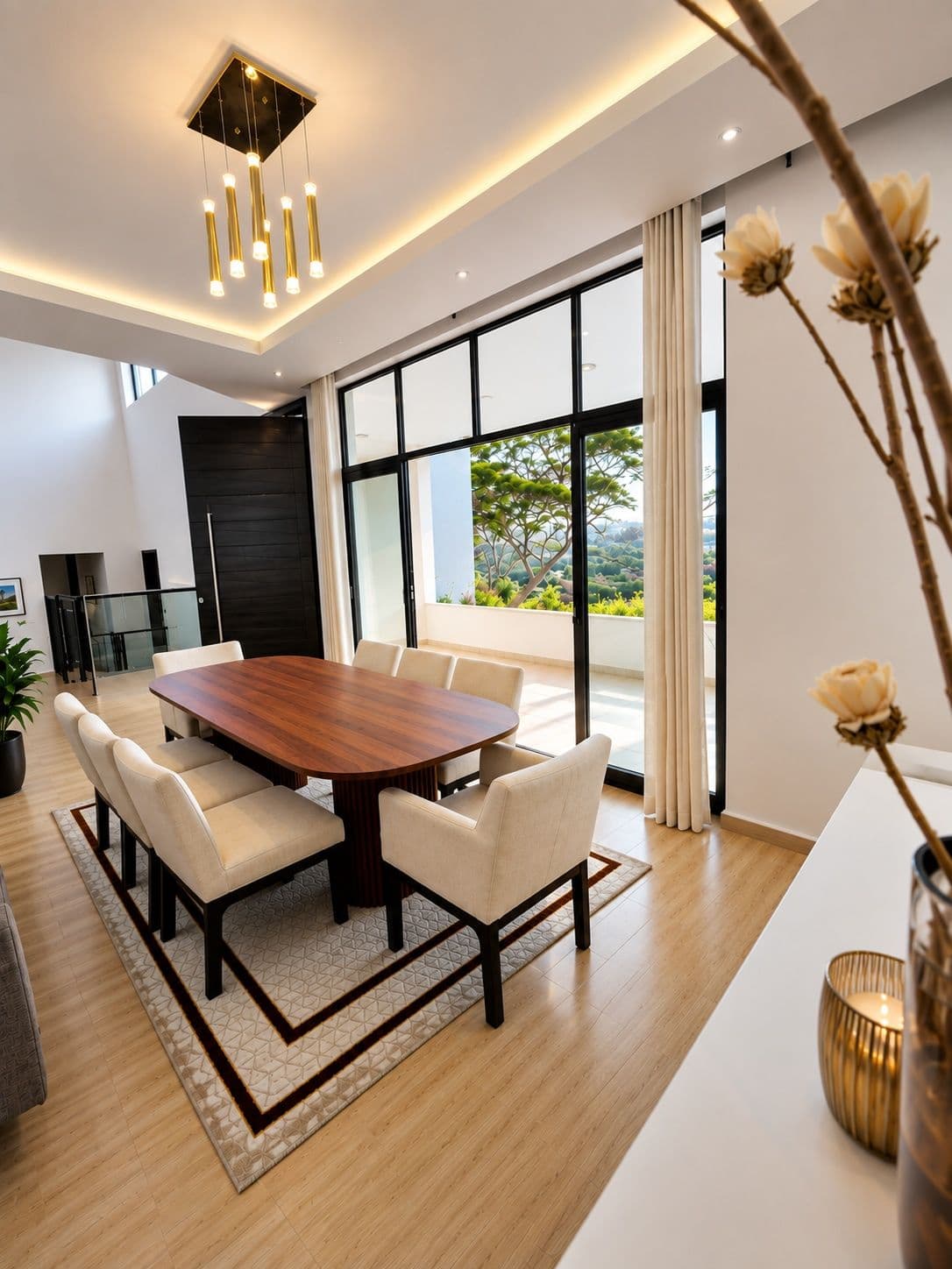 The dining area, with cream chairs, a wood table and the garden outside. Urugwiro, Kacyiru.
